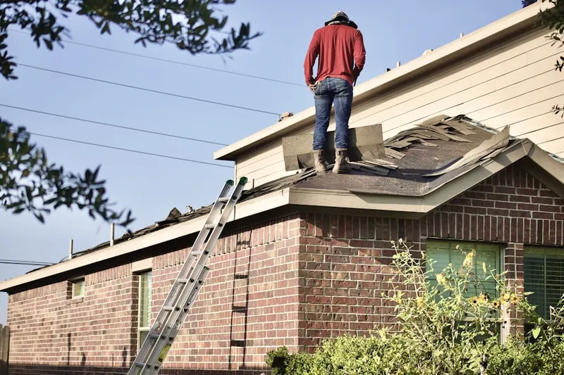 Professional roofer working on a residential roof in West Revere